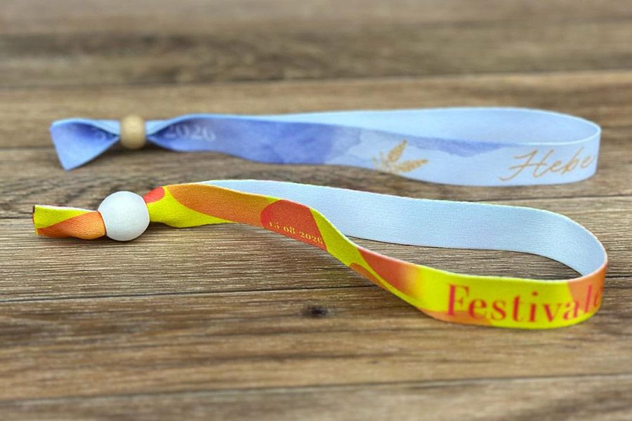 2 geprinte festivalbandjes met herbruikbare sluiting - vooraan een houten sluiting en achteraan een bamboe sluiting die wat subtieler is